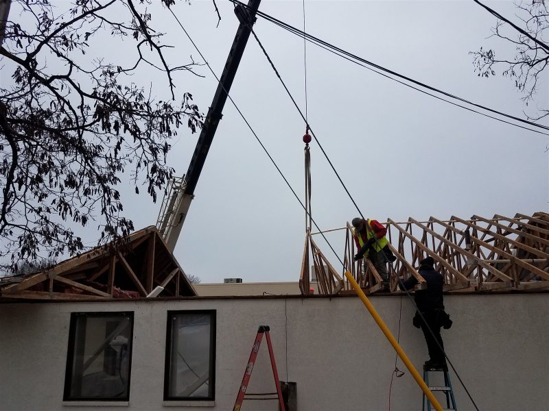 Wheeler crew setting roof trusses during a commercial roof reconstruction